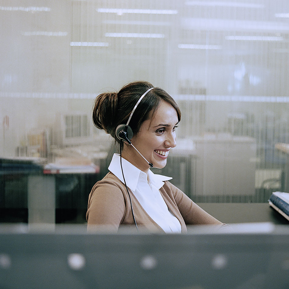 Close-up of smiling mature female customer service representative wearing headset in office
