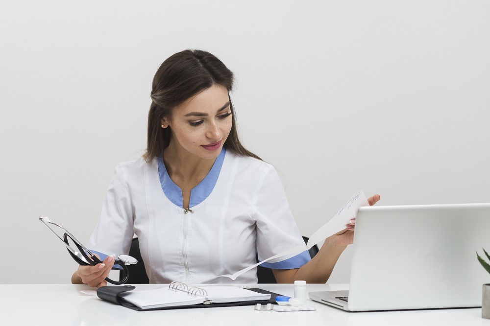 young female doctor looking medical reports